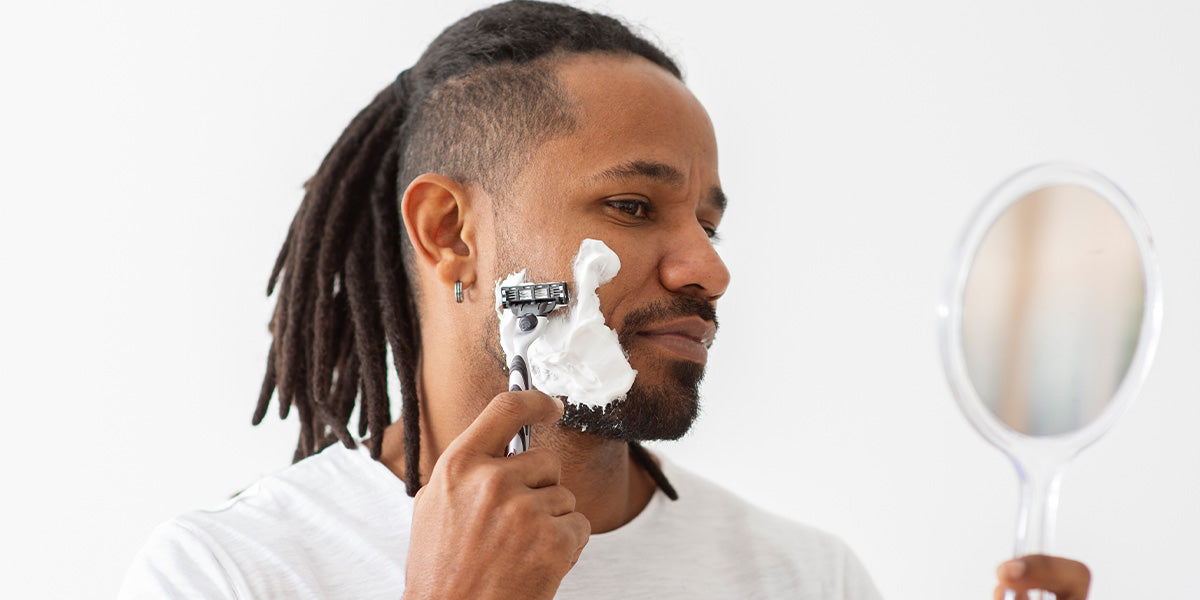 A man shaving his beard to prevent ingrown hairs.