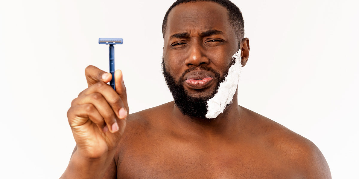 A man of color holding a razor