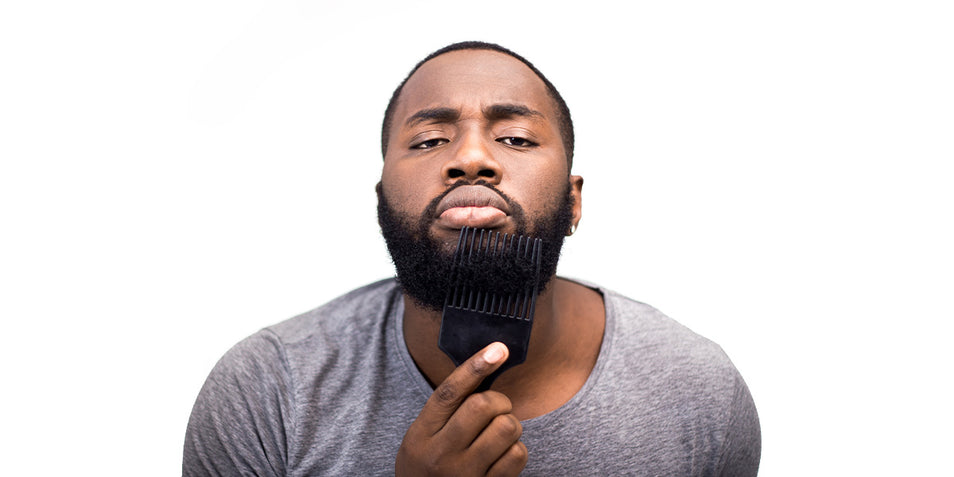 A man combing his black coarse beard.